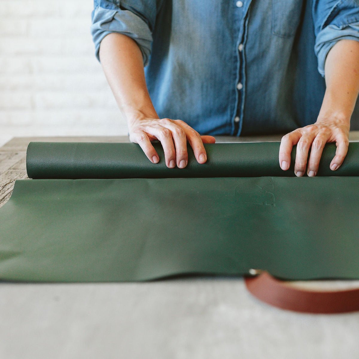 Green foldable repotting mat laid flat with plant and soil on top for mess-free repotting