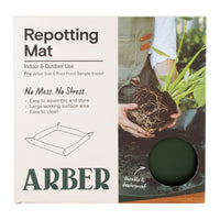 Green foldable repotting mat laid flat with plant and soil on top for mess-free repotting