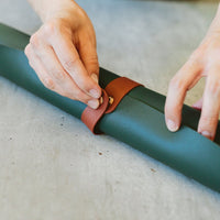 Green foldable repotting mat laid flat with plant and soil on top for mess-free repotting